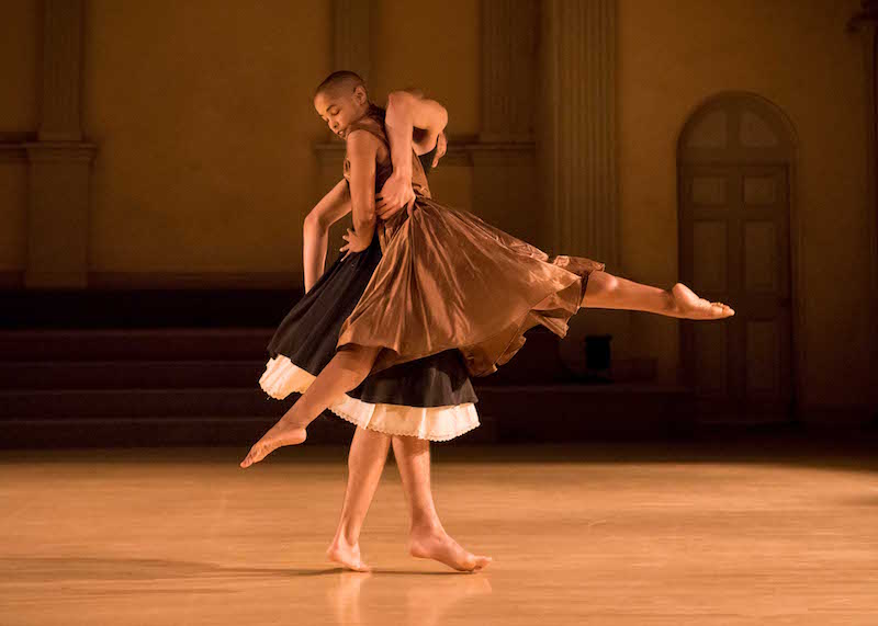 Jasmine in a bronze dress is lifted by her partner